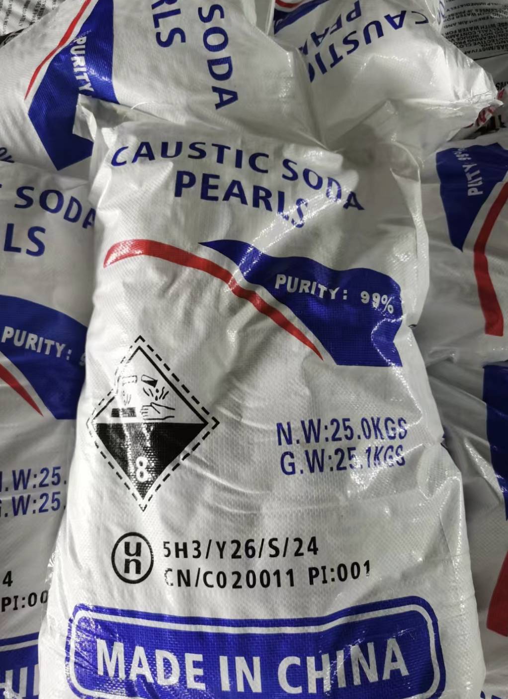 25 kg bags of caustic soda pearls labeled 99% purity for soap manufacturing and industrial use.